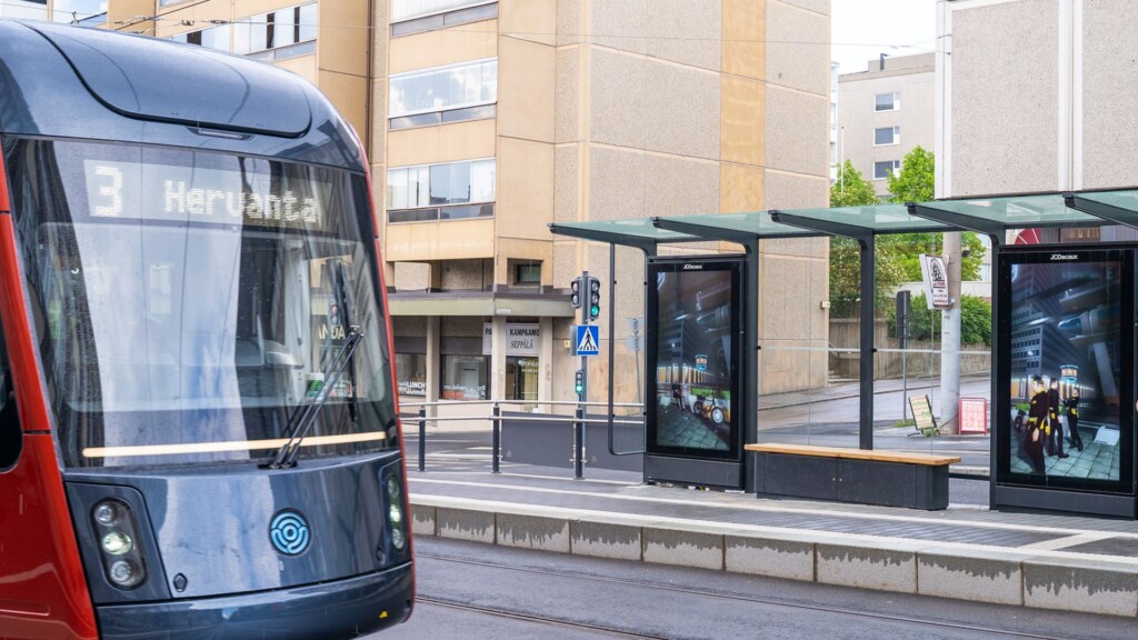 Tampereen Ratikka pysähtyneenä Tullin pysäkille. Taustalla näkyy pysäkkikatos.