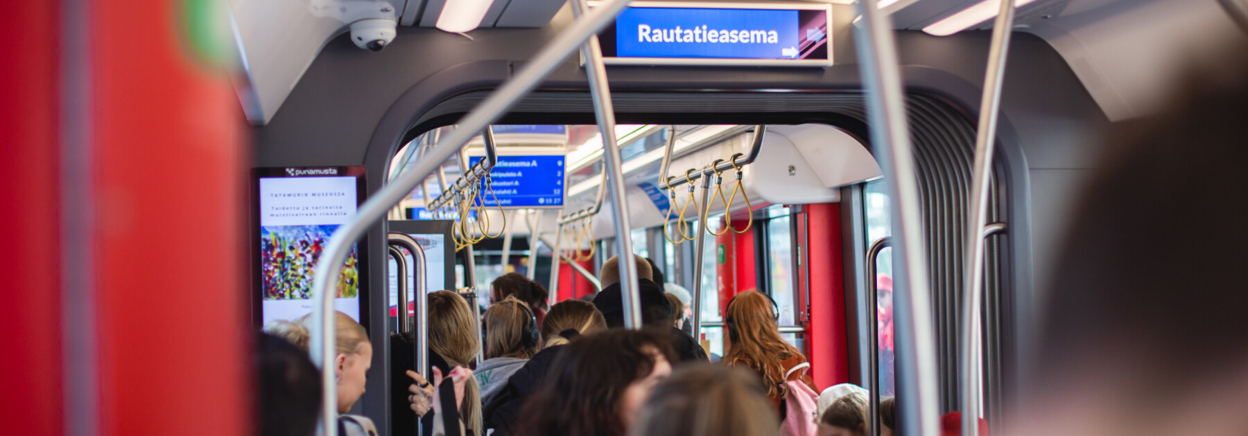 Matkustajia Tampereen Ratikassa keväällä 2024